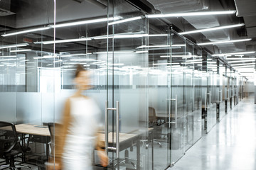 View of a modern office intreior with blurred woman figure in the hallway