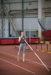 Obraz premium Pole vaulting - woman is holding a long pole in her hands