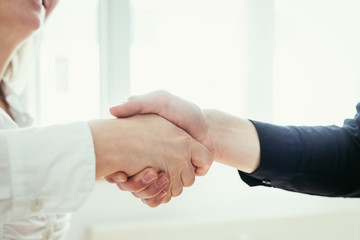 Shaking hands, concept for teamwork: Close up of man and woman shaking hands in the office