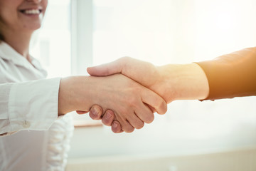 Shaking hands, concept for teamwork: Close up of man and woman shaking hands in the office
