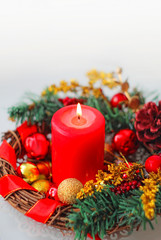Fototapeta na wymiar Burning Christmas red candle and festive Christmas composition on white background. Christmas advent. Christmas and new year holiday concept. soft selective focus. close up