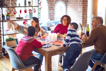 Beautiful family smiling happy and confident. Eating roasted turkey make selfie by smartphone celebrating christmas at home