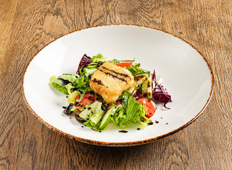 salad with fish on the wooden background