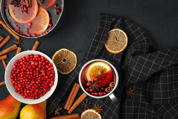 Top view of  hot mulled wine and spices on black background
