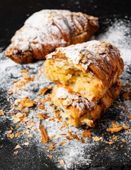 Croissants with almonds on the black background
