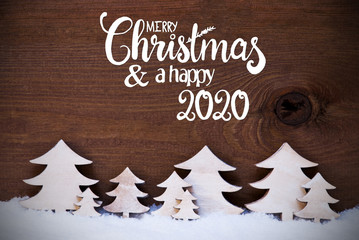 Fototapeta na wymiar English Calligraphy Merry Christmas And Happy 2020. White Wooden Trees On Snow WIth Wooden Background