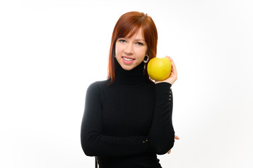 Healthy food concept. Portrait of a pretty red-haired student girl with long smooth hair on a white background in a black sweater with an apple in her hands. Talking, showing emotions, smiling.