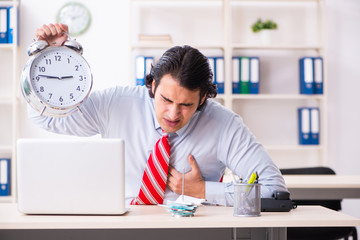 Young male employee suffering in the office