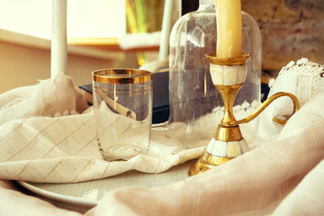 Golden candlestick and glass on the table