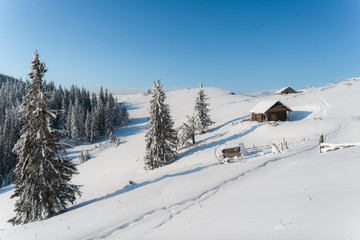 Fototapeta na wymiar Fantastic winter landscape with wooden house in snowy mountains. Christmas holiday concept. Carpathians mountain, Ukraine, Europe