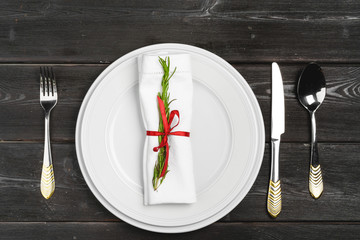 Festive table setting with pine tree branches on wooden background