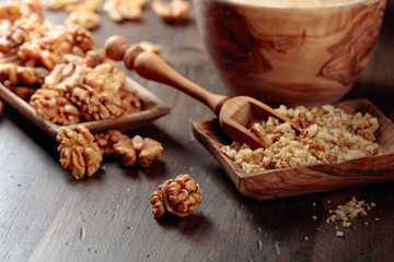 Walnuts in a wooden dish on an old wooden table.