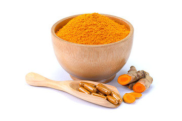 Turmeric powder in wooden bowl , tumeric root and capsules in scoop ( known as curcumin, Curcuma...