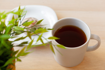 Obraz na płótnie Canvas Cup of hot black tea close up on wooden table