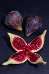 natural black figs grouped and open on black background