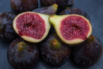 natural black figs grouped and open on black background