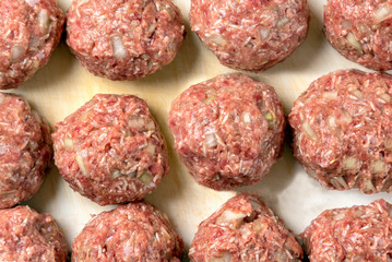 Raw balls of ground beef with spices for the preparation of hamburgers, meatballs.