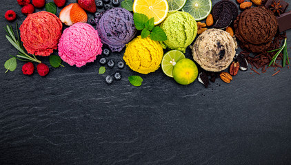 Various of ice cream flavor ball blueberry ,lime ,pistachio ,almond ,orange ,chocolate and vanilla set up on dark stone background . Summer and Sweet menu concept.
