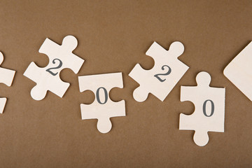 Puzzle pieces with text 2020 on a brown background