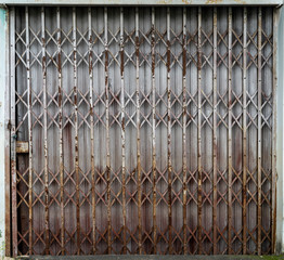 Vintage Shutter door, old rusted iron sliding gates texture. Rusty old iron door of abandoned house and deteriorate Background and wallpaper.