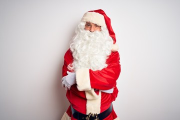Middle age handsome man wearing Santa costume standing over isolated white background happy face smiling with crossed arms looking at the camera. Positive person.