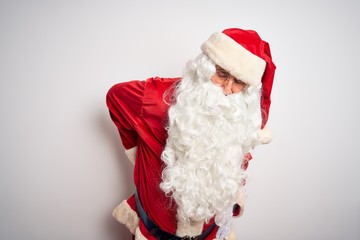 Middle age handsome man wearing Santa costume standing over isolated white background Suffering of...