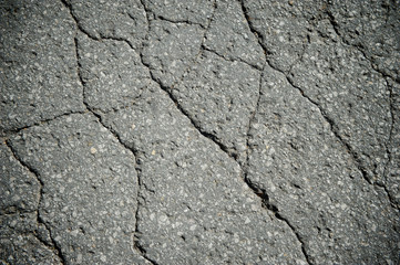 Full frame grunge background of cracked old asphalt pavement 