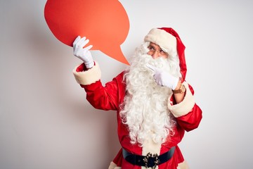 Middle age man wearing Santa costume holding speech bubble over isolated white background very happy pointing with hand and finger