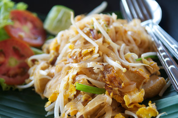 Fresh, mouthwatering close-up of plate of traditional vegetarian Pad Thai noodles served on banana leaf