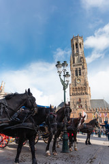 Naklejka na ściany i meble Belfort tower in Bruges at the Market Square with horses, Belgium.