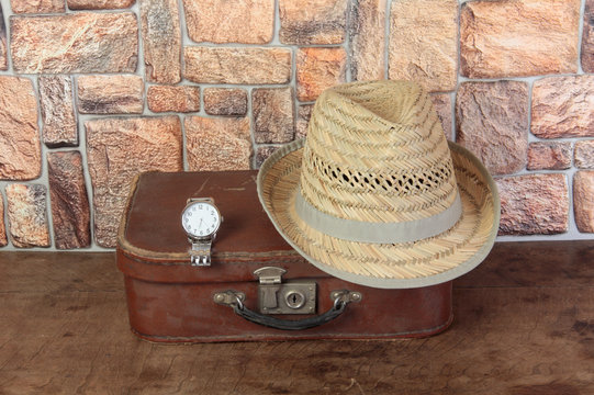 Old suitcase and personal items on a wooden table