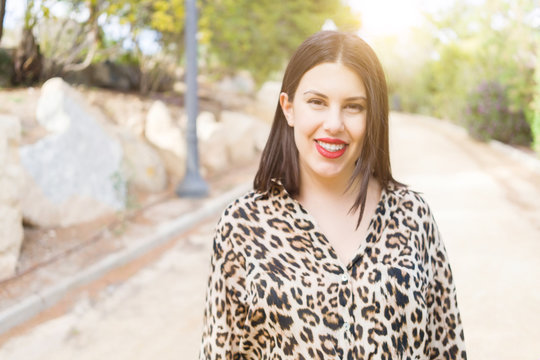 Young beautiful woman with red lips smiling happy at garden