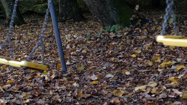 Old swing-set moving in slow motion, no people in clip. Concept child abduction.