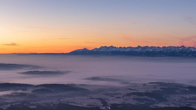Sunrise over Tatra mountains seen from Babia mountain with cloud inversion. Video with camera motion.