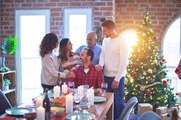 Beautiful family smiling happy and confident. Standing and posing with tree celebrating Christmas at home