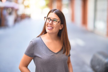 Young beautiful woman smiling happy and confident. Standing with smile on face at town street