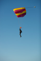 Skydiver piloting a sports parachute, side view against a blue sky. Parachute jumps. Skydiving.