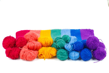 Rainbow knitted fabric and balls of wool thread isolated on white background