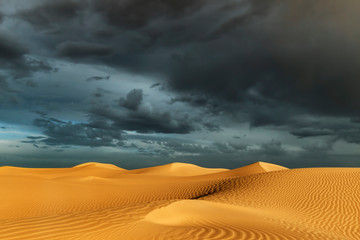 Sahara sand dunes with stormy, cloudy sky at Erg Lihoudi.