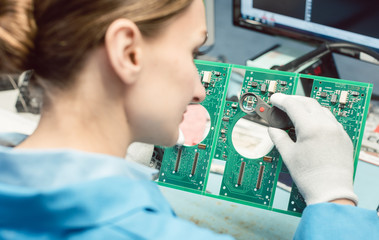 Technician soldering components to a PCB