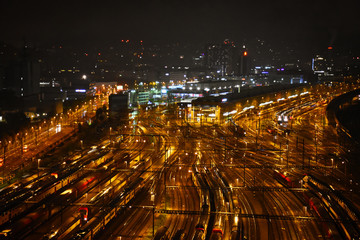 Fototapeta na wymiar Aerial view of freight, cargo and passenger trains waiting at the train station parking lot during the night