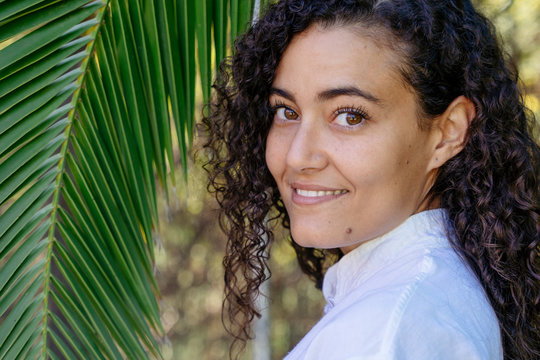 Portrait Of Beautiful Ethnic Arab Woman Surrounded By Nature. Isolated Female With Arabian Features On Her Dark Skin Holding A Green Leaf. Equality For Arab Women Concept. Travel Around The World.