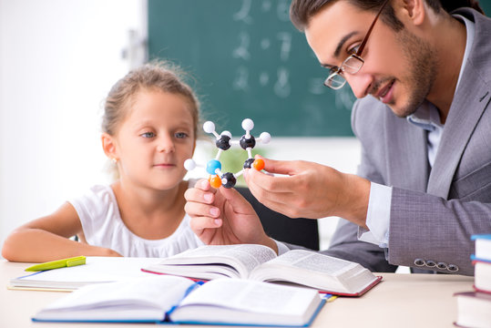 Teacher with young girl in the classroom