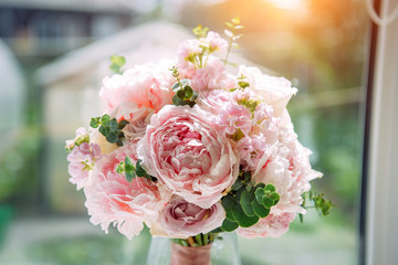 Lush bridal bouquet of pale pink flowers, close-up, blurred background. Wedding concept, postcard.