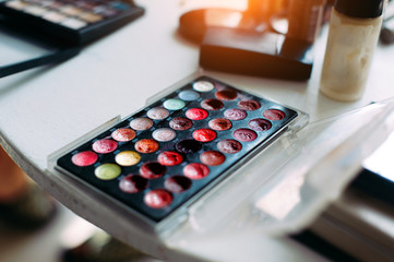 Cosmetics for professional makeup. Makeup artist set, close-up. Cream eye shadows, a blush, palette...