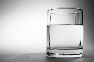 Glass of drinking water on gray background