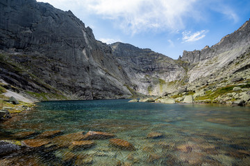Naklejka na ściany i meble A magnificent mountain lake surrounded by cliffs
