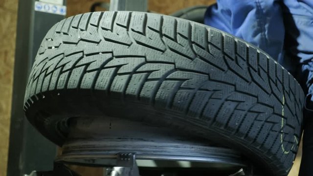 Change a tyre, Car mechanic is changing a tyre in a garage