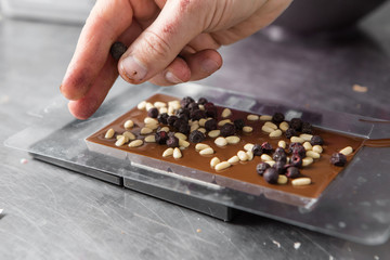 making chocolate with berries at confectionery shop kitchen
