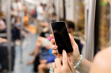 Person using mobile phone in metro